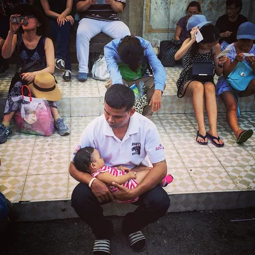 A man holds his exhausted sleeping baby while other Chatu