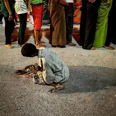 An Indian man collects a coin as he begs for alms in the 