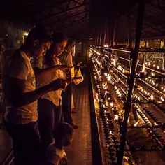 A family lights clay lamps together after the evening rel