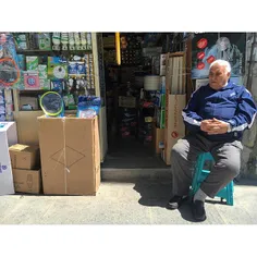 A gentleman is sitting outside his shop in #Naserkhosro, 