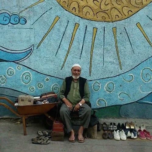 An Afghan man who repairs shoes at the side of a street i