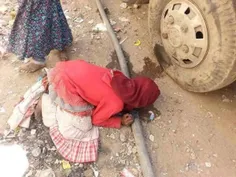 دختر خردسال #یمنی که از فرط تشنگی سعی دارد از نشتی لوله د
