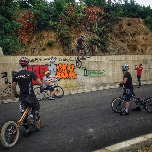 A group of young trial bike riders climbs walls, sculptur