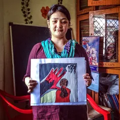 22 year old Ningma holds a painting she did at the Free a