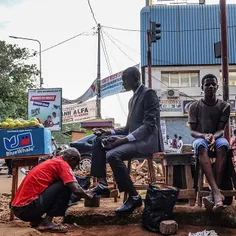 An accountant on his way to work in Conakry gets his shoe