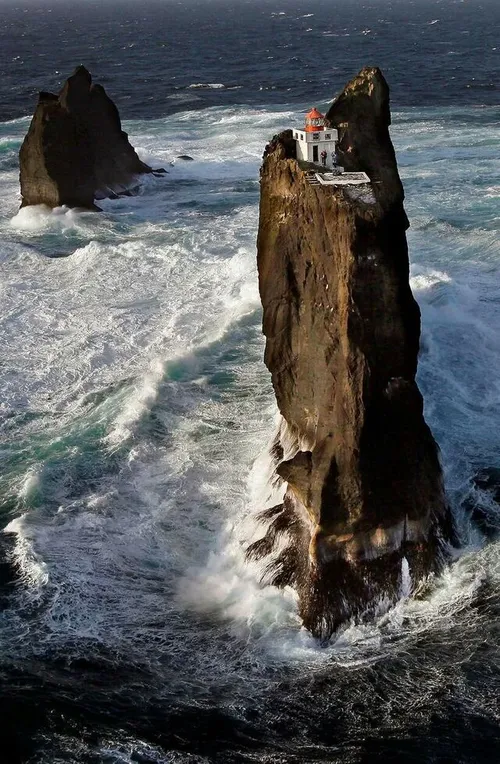تصویری از یک فانوس دریایی بر بالای صخره ای بزرگ در ایسلند