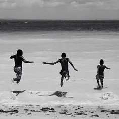 Kids run into the ocean in Gamboa, Bahia, Brazil. Picture