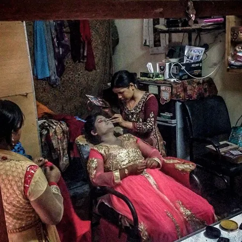 A woman has her makeup done in a salon before a party in 