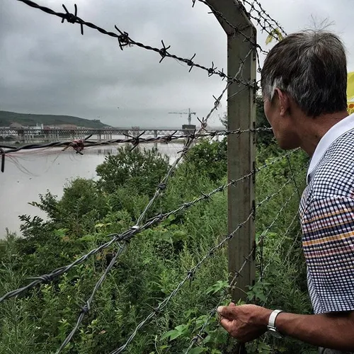 An old man look at North Korean territory over the iron f