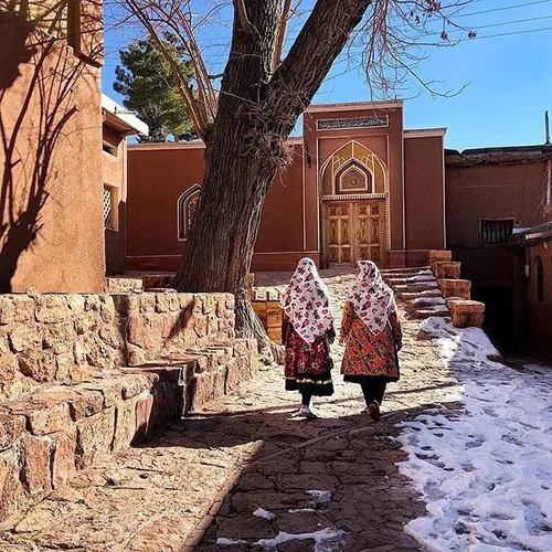 Tourists wearing traditional clothes of Abyaneh walk in t
