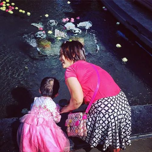 Mother and daughter float their lotus flowers at the Eraw