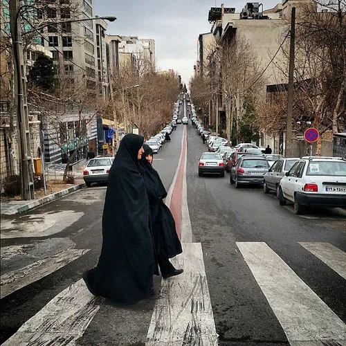Women crossing over a street. Tehran, Iran. Photo by Abol
