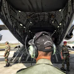 An Indian Army personnel directs an Indian Air Force airc