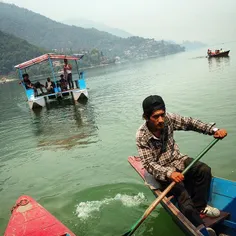 A Nepalese young man rowing the boat, taking people to Ta