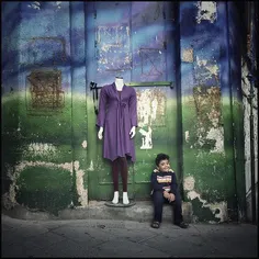 A kid sits beside a mannequin on a sidewalk. #Tabriz, #Ea