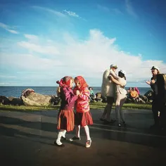 Kids in traditional Kihnu dresses are dancing at the harb