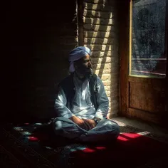 A Sunni man waits for the time of Noon Prayer at a mosque