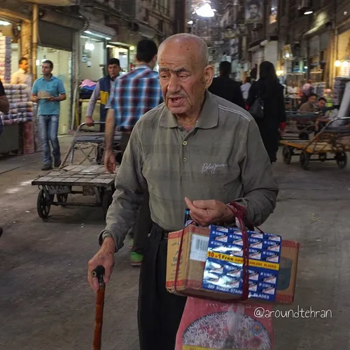 An old man is selling things in the grand bazaar of Tehra
