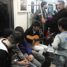 A musician playing the guitar in a subway train. #Tehran,