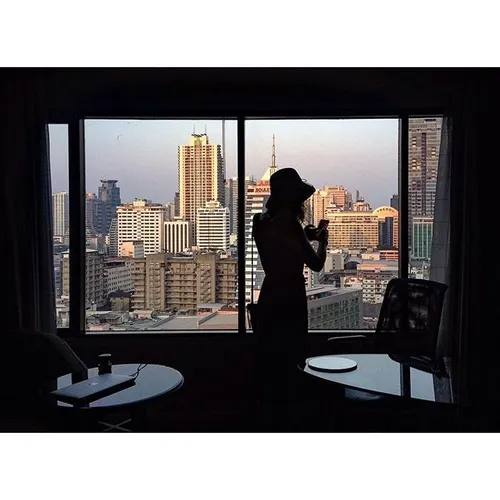 A foreigner takes a photo of the Bangkok skyline at a hot