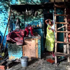 43 years old, Radha Kanojia looks out of her house as she