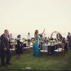 A woman takes photographs from her phone at a wedding as 