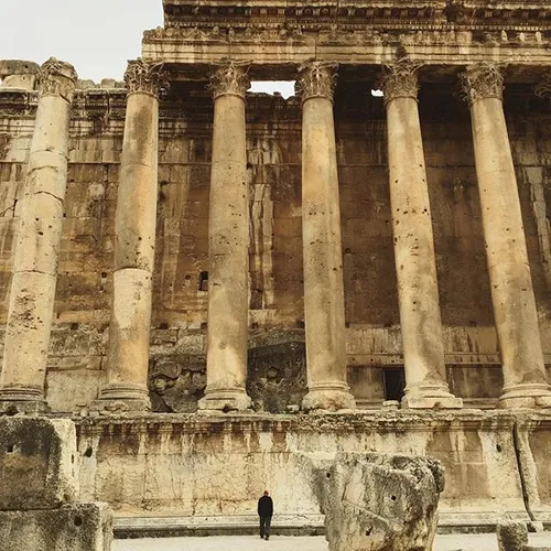 A visitor stands under the Temple of Bacchus in the Roman