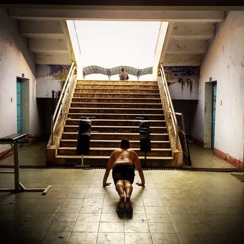 A man practices bodybuilding inside a gym stadium basemen