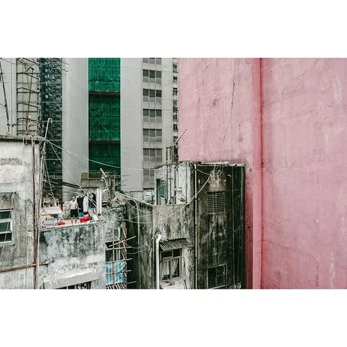 An elderly man doing his laundry on the rooftop in Hong K