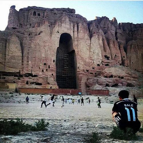 Teenagers playing football in front the largest and destr