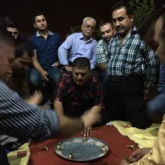 A group of Turkmen play an animated game of sini at a caf