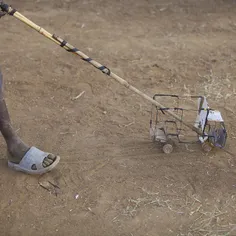 A boy "drives" a toy car made out of wires in Kotido dist