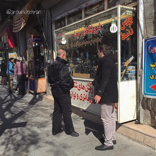 Men are standing outside a camera shop selling Russian pr