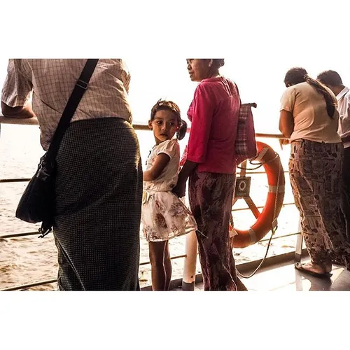 A young girl crosses the Yangon River with her grandparen