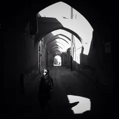 A young woman walks through an old neighborhood of #Yazd,