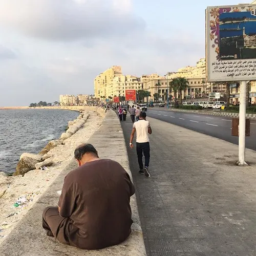 A man reads the newspaper on the Alexandria corniche in e
