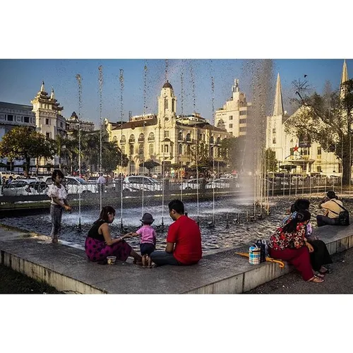Families sit by the fountains in Yangon's Mahabandoola Pa