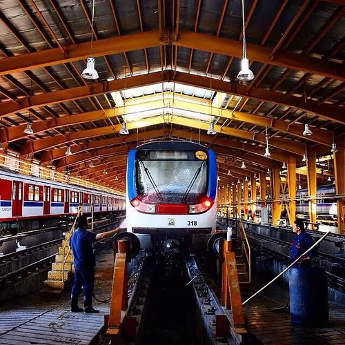 Staff members of Tehran Metro washing a train in a railwa