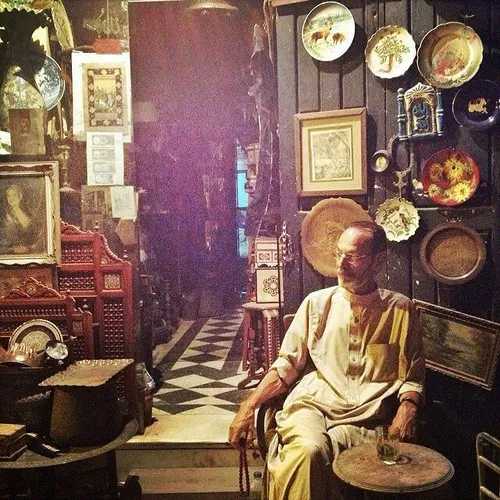 A shop owner sits by his antique store after Iftar in Isl