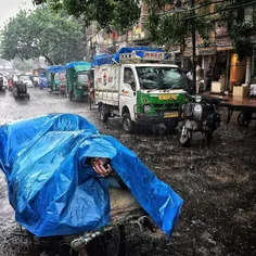 An Indian labourer looks on as he covers himself with a t