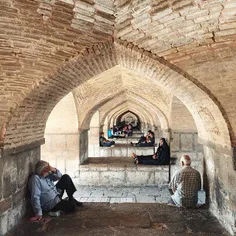 Men while away the hours under Khajou Bridge. Serving as 