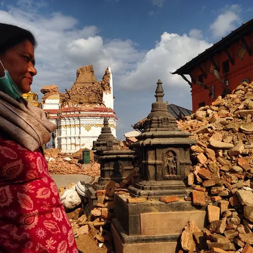 A woman rest near debris near swayabhunath stupa hit by e