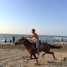 A man rides on a horse on the coast of #MahmoodAbad, #Maz