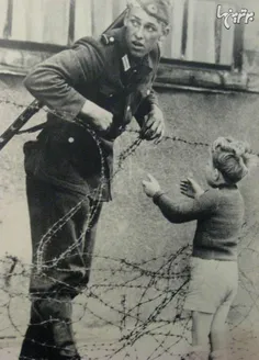 سربازی که به یک پسر از آلمان شرقی برای عبور از دیوار برلی