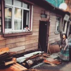A Turkish woman chops wood outside her house in the Fatih