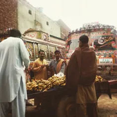People standing around a fruit cart vendor in chilly Laho