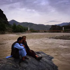 Two men sitting out the end of the day on the River Kokch