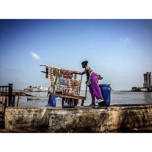 A woman sells snacks on the sea wall in Mumbai, India. Ph