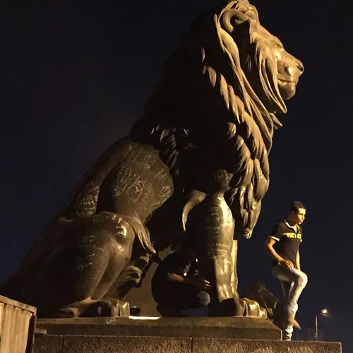 Youth pose in front of the lion statues of Qasr Al-Nile b