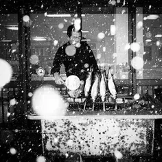 A fisherman grilling herrings in snow in Otaru, Hokkaido.